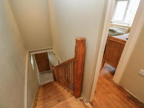 a stairwell with a wooden rail in a room at Perranglaze in Truro