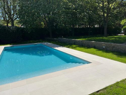 a swimming pool in a yard with a stone wall at Espectacular Casa Chateau en el centro de Olot in Olot