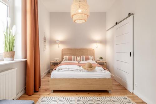 a bedroom with a bed with white walls and orange curtains at Sanhaus Apartments - Apartament Kite and Surf przy plaży in Sopot