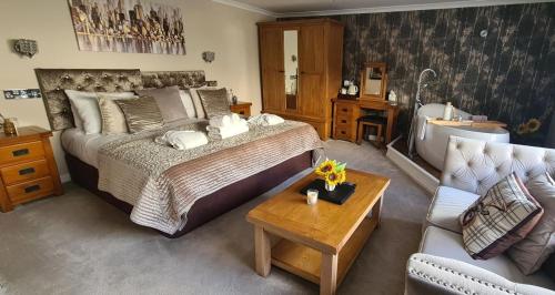 ein Schlafzimmer mit einem Bett, einer Badewanne und einer Couch in der Unterkunft Black Bull Inn, Moffat in Moffat