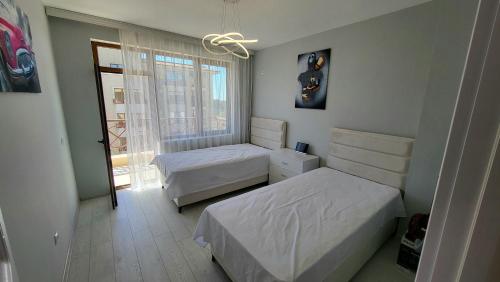a small bedroom with two beds and a window at EL-EM Apartments-G 402 in Balchik