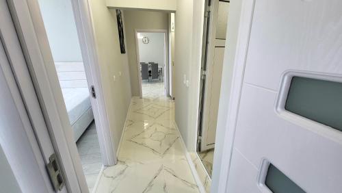 a hallway with a marble floor and a mirror at EL-EM Apartments-G 402 in Balchik