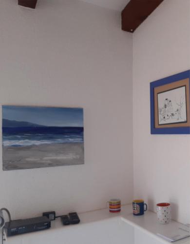 une peinture de l'océan sur un mur blanc dans l'établissement La terrazza sulla baia di Calvi, à Lumio