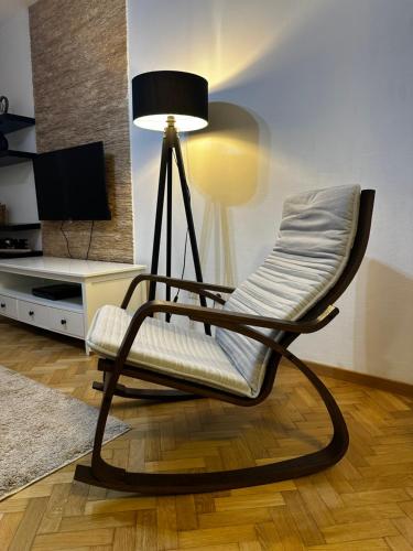 a chair with a lamp in a living room at City apartment with the sea view in Bar