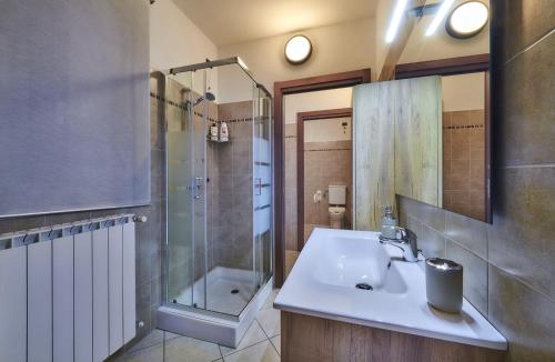 La salle de bains est pourvue d'un lavabo et d'une douche. dans l'établissement La casa di Cinzia central apartment, à Lierna