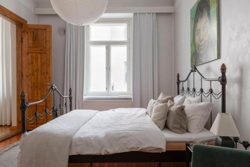 ein Schlafzimmer mit einem Bett mit weißen Laken und einem Fenster in der Unterkunft Charming Flat in Design District in Helsinki