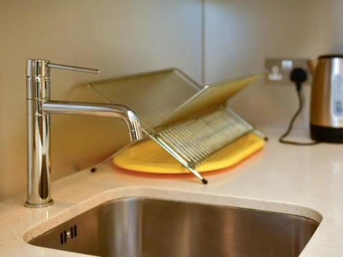 Un colador de metal colocado encima de un fregadero de cocina. en Pass the Keys Perfectly Located Apartment, en Cardiff