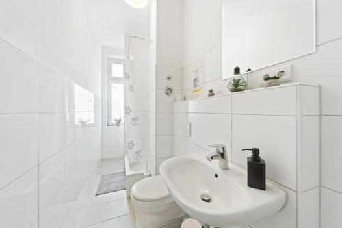 Baño blanco con lavabo y aseo en home2stay Apartmenthaus Halle Zentrum Parking,Kitchen,Wifi ***, en Halle an der Saale