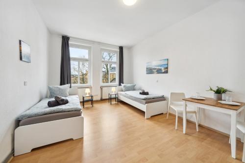 Sala de estar con 2 camas y mesa en home2stay Apartmenthaus Halle Zentrum Parking,Kitchen,Wifi ***, en Halle an der Saale