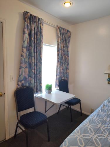 een kamer met een tafel, 2 stoelen en een raam bij Colorado Inn Motel in Canon City