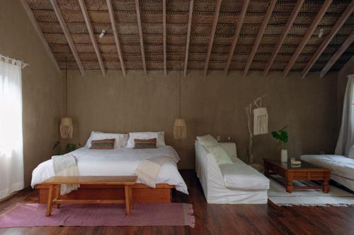 a bedroom with a large bed and a couch at La Fragata in Vichayito