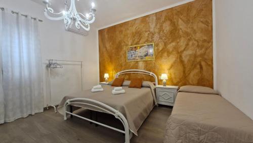1 Schlafzimmer mit 2 Betten und einem Kronleuchter in der Unterkunft Casa Vacanze sul Corso in Giarre