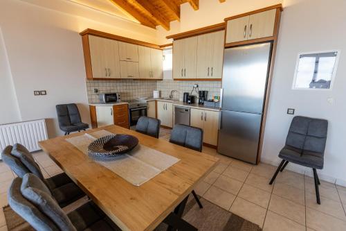 a kitchen with a wooden table and a refrigerator at ΑμφιΘΕΑ! στη ΝΑΥΠΑΚΤΟ ! in Nafpaktos