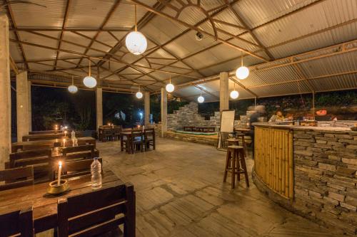 un restaurante con un patio con mesas y sillas en Borderlands Eco-Adveture Resort en Ghunthang
