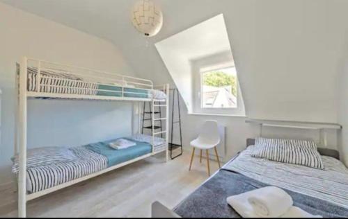 - une chambre avec 2 lits superposés et une chaise dans l'établissement Les Cerisiers du Rouz, à Fouesnant