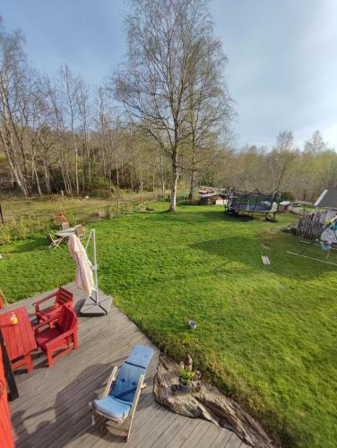 a deck with chairs and a picnic table and a playground at Villaidyll i Svanesund nära havet in Svanesund