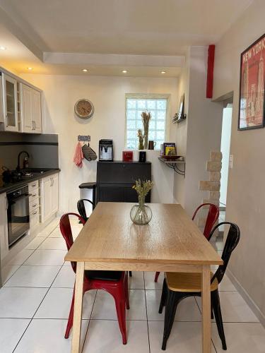 une cuisine avec une table en bois et des chaises rouges dans l'établissement Charmant appt Endoume - proche mer et Vx Port, à Marseille
