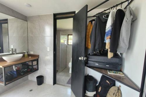 a bathroom with a closet with a sink and a mirror at Villa Monarca, Hermosa Casa cerca a Villa de Leyva in Villa de Leyva