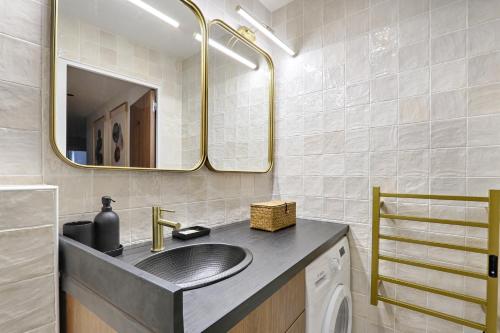 une salle de bain avec un lavabo et un miroir dans l'établissement Sentier Historical Center Luxury & Design Apartment 2BR, à Paris