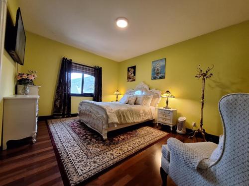 a bedroom with yellow walls and a bed and a couch at Summer Express Kelowna B&B - Villa Bellissimo Fran-Talia in Kelowna