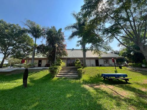 a house with a blue bench in a yard at Hotel Tum's Water World in Manzini