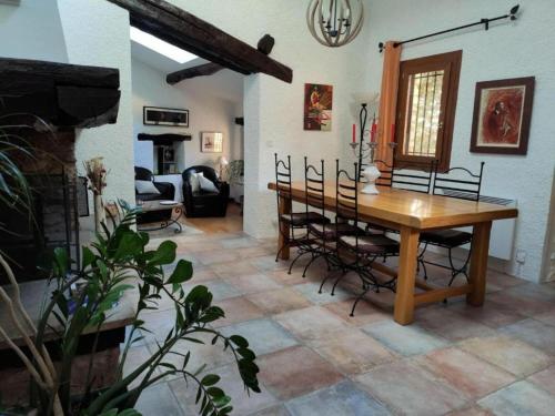 - une salle à manger avec une table et des chaises en bois dans l'établissement Les chambres du Mas Peu del Causse, 