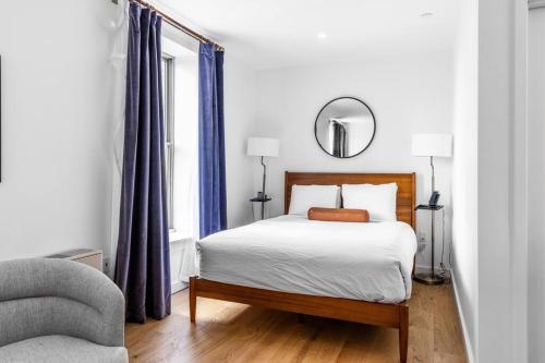 a white bedroom with a bed and a mirror at Historic BLDG, Coffee Shop, FAST Wi-Fi, Room # 207 in Bangor