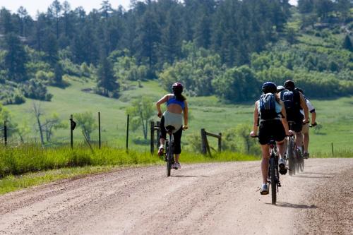 three people riding bikes down a dirt road at Zephyr Slopeside - 1504 condo in Winter Park