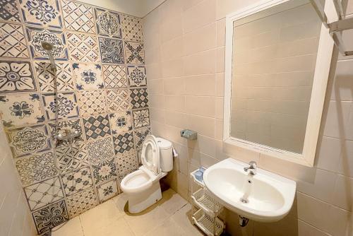 La salle de bains est pourvue de toilettes et d'un lavabo. dans l'établissement Mooi Inn City Center Surabaya, à Surabaya