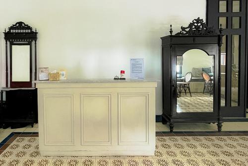 - un comptoir blanc avec un miroir dans la chambre dans l'établissement Mooi Inn City Center Surabaya, à Surabaya