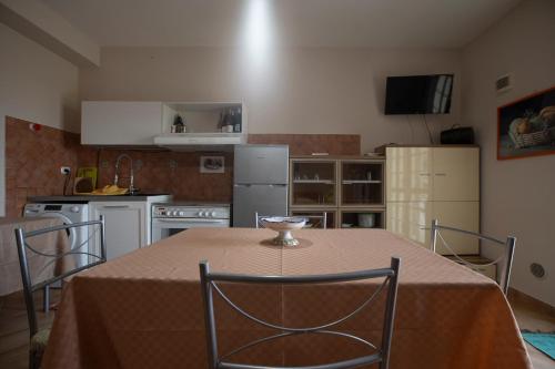 une cuisine avec une table et des chaises ainsi qu'une cuisine avec une table et des chaises dans l'établissement La maison, à Alcamo