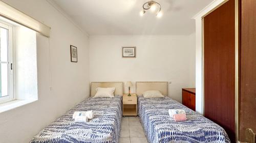 two beds in a small room with a window at Quinta de Sta Teresa by Villas Key in Lagoa