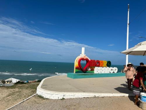 a colorful statue on the beach next to the ocean at Apto com Ar com vista para praia de Morro Branco - Fortaleza in Beberibe