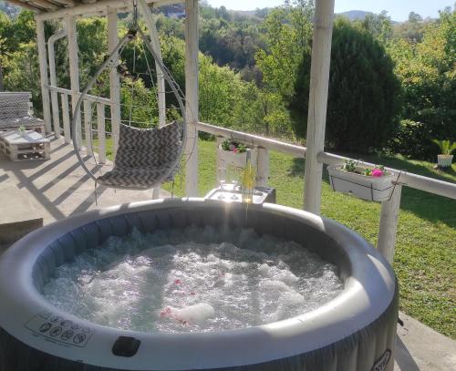a hot tub on a patio with a swing at Vila Obradovic in Arilje