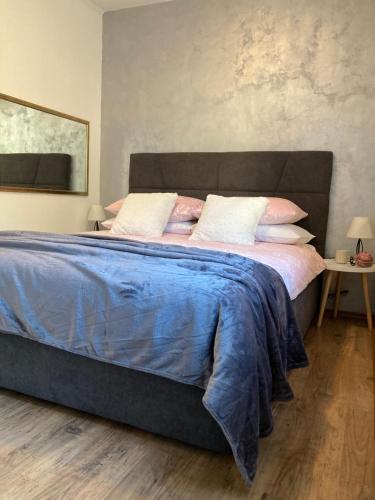 duże łóżko z niebieskim kocem i poduszkami w obiekcie Apartment Panarea w Dubrowniku