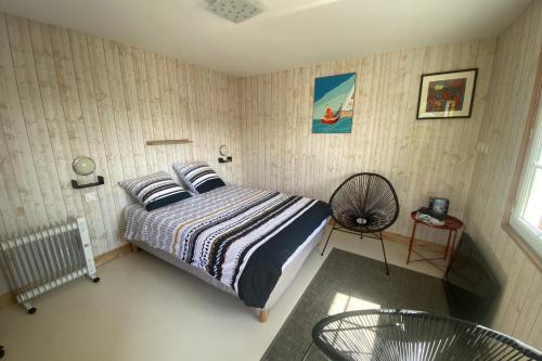 - une chambre avec un lit et un ventilateur dans l'établissement Chalet Rive Bellacha near Ouistreham beach, à Ouistreham