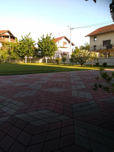a brick patio in a yard with houses in the background at Apartman Aleksandar in Banja Luka