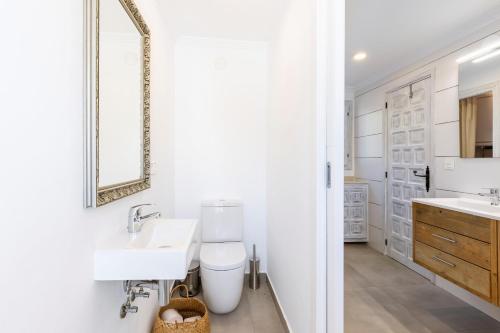 uma casa de banho branca com um lavatório e um espelho em Casa Nero em Jávea