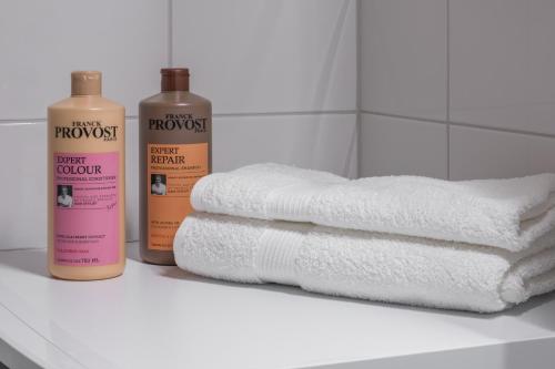 a pile of towels sitting on a shelf next to towels at Modern studio by Finnoo metro in Espoo