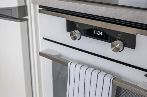 a kitchen oven with a clock on it at Modern studio by Finnoo metro in Espoo