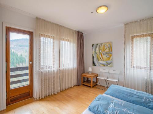 a bedroom with a bed and a table and a window at Kurhaus am Nordenau - 10 pers in Schmallenberg