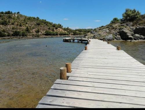 a wooden dock in the middle of a body of water at Logis Hotel De La Clape in Narbonne-Plage