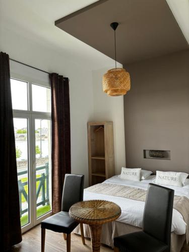 a bedroom with a bed and a table and chairs at Rive Gauche in Saumur