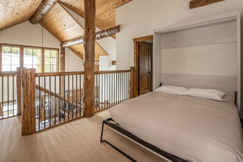 ビッグスカイにあるSpanish Peaks | Homestead Cabin 59のベッドルーム(ベッド1台付)、バルコニーが備わります。