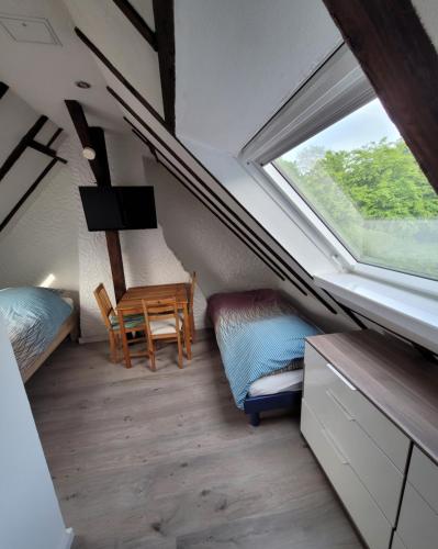 ein Schlafzimmer mit einem Fenster, einem Bett und einem Schreibtisch in der Unterkunft Messezimmer am Thewissenweg in Düsseldorf