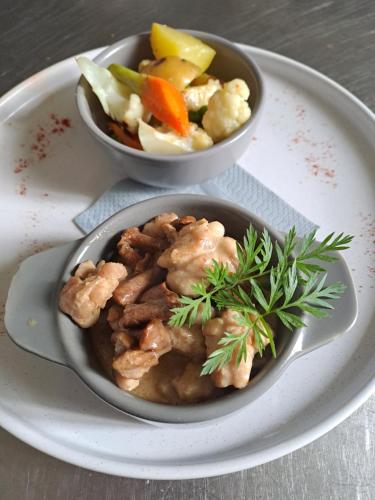deux bols de nourriture dans une assiette avec des légumes dans l'établissement Les Chambres du Cheval Blanc, à Allassac