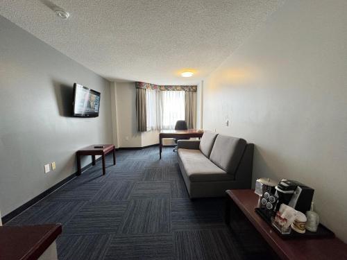 a living room with a couch and a table at Divya Sutra Plaza and Conference Centre Calgary Airport in Calgary