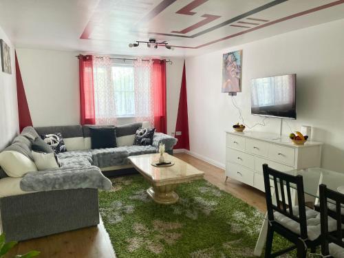 Westfield Grove 3 Bedroom Apartment في Goodmayes: غرفة معيشة مع أريكة وتلفزيون
