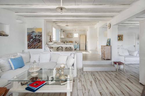 a living room with a white couch and a table at Samanti House, Leivadi Serifos in Livadi
