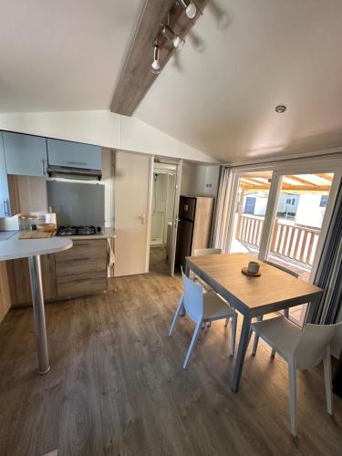 a kitchen and dining room with a table and chairs at Large Mobile Home on 4star Camping in Capbreton